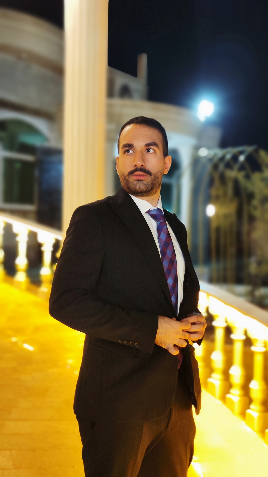 Amin Sakha in formal attire in an architectural setting